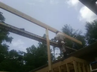 Carpenter setting a ridge beam over a new addition frame — Ice Dam Removal by Roofing Brothers in Otterbein