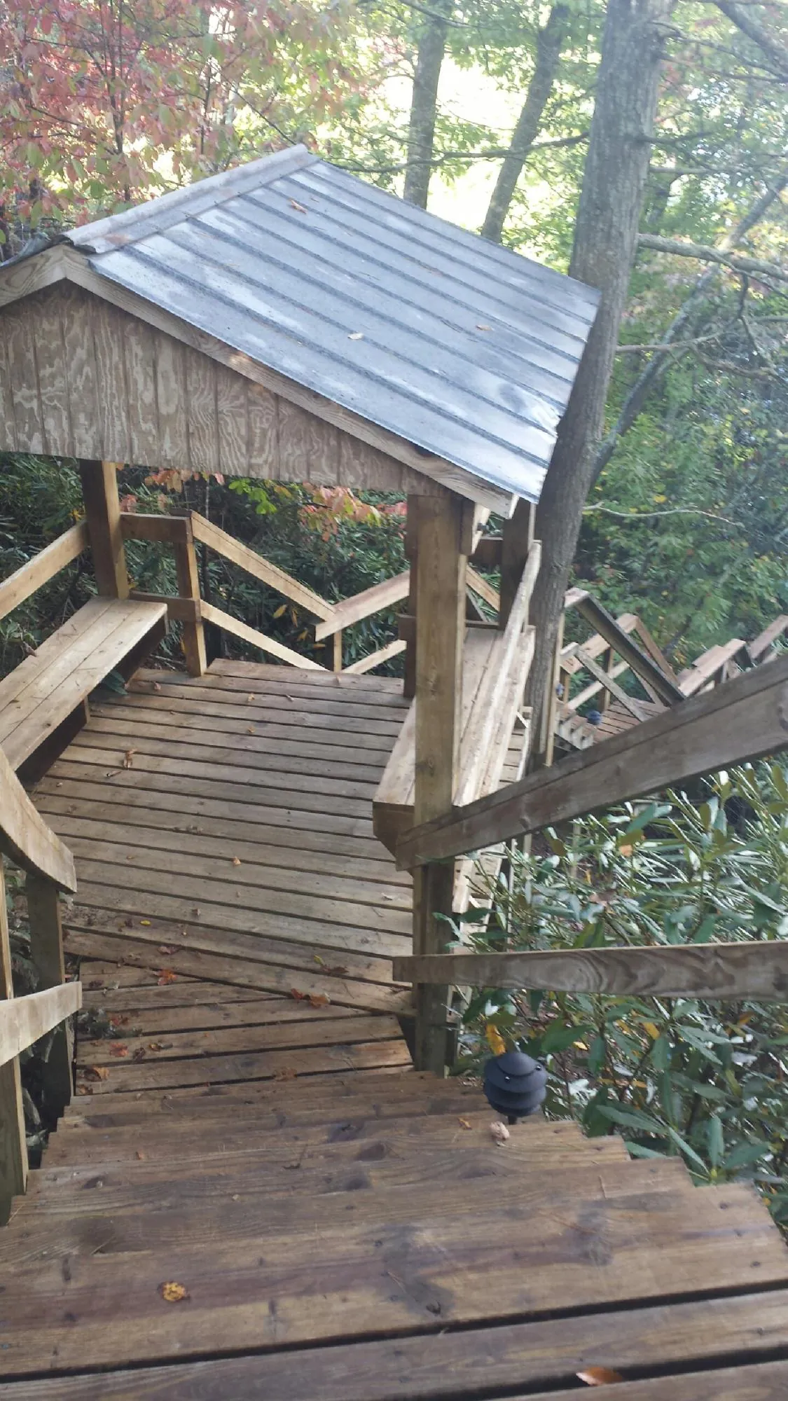 Metal roofed shelter over wooden steps on a wooded walkway — Skylight Repair & Installation work by our crew in Otterbein